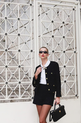 a lady in a white shirt, a black jacket and a pair of black shorts